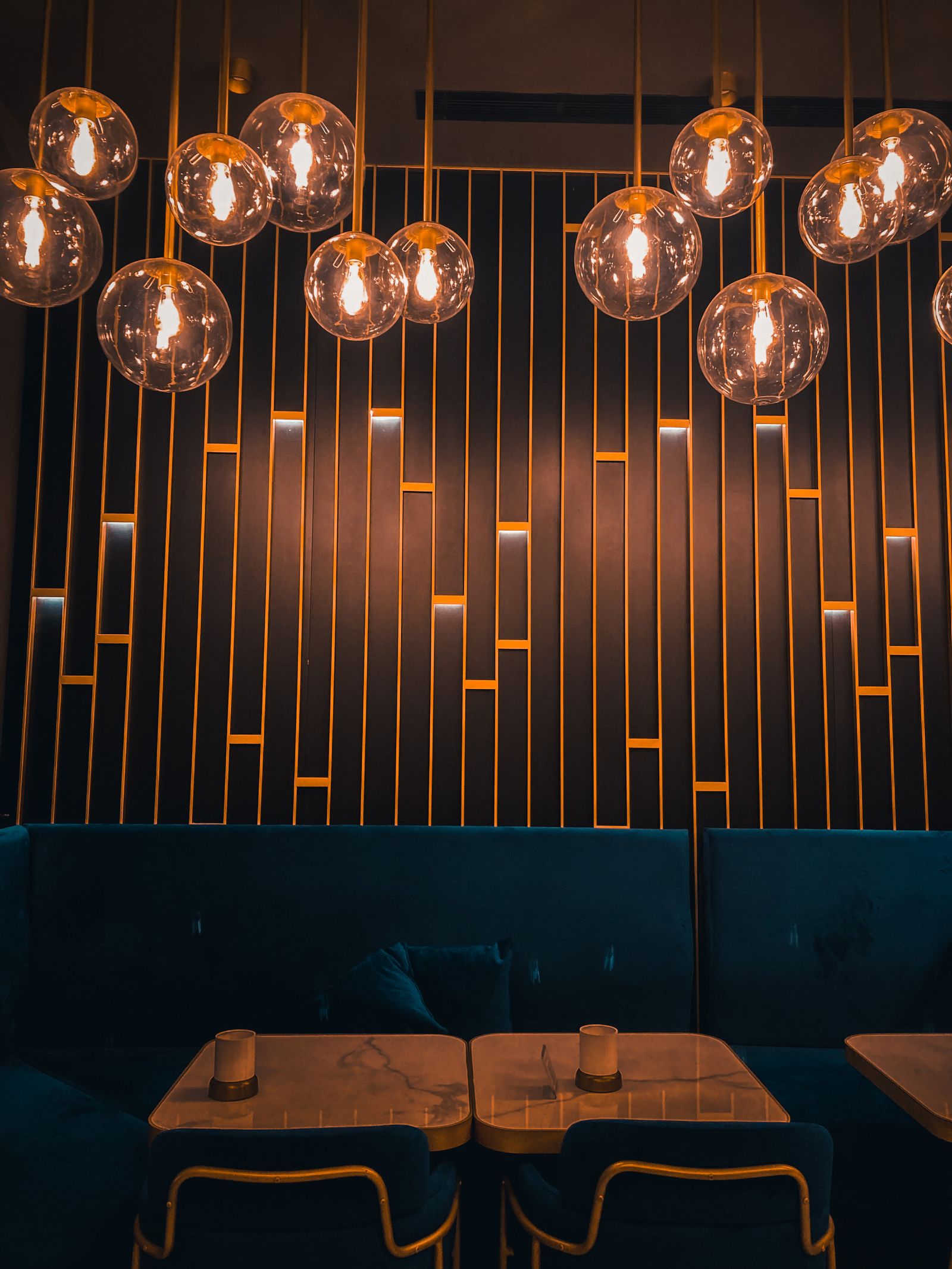 Glass globe pendant lights over plush booth seating