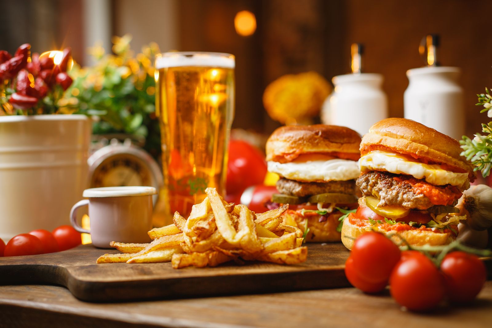 Burgers with fries and a pint of lager on a rustic table